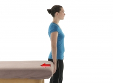 A woman pushing backwards against a table