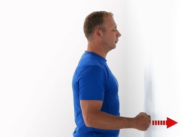 A photo of a man doing gentle pushes against a wall with his fist