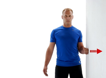 A photo of a man doing gentle pushes against a wall